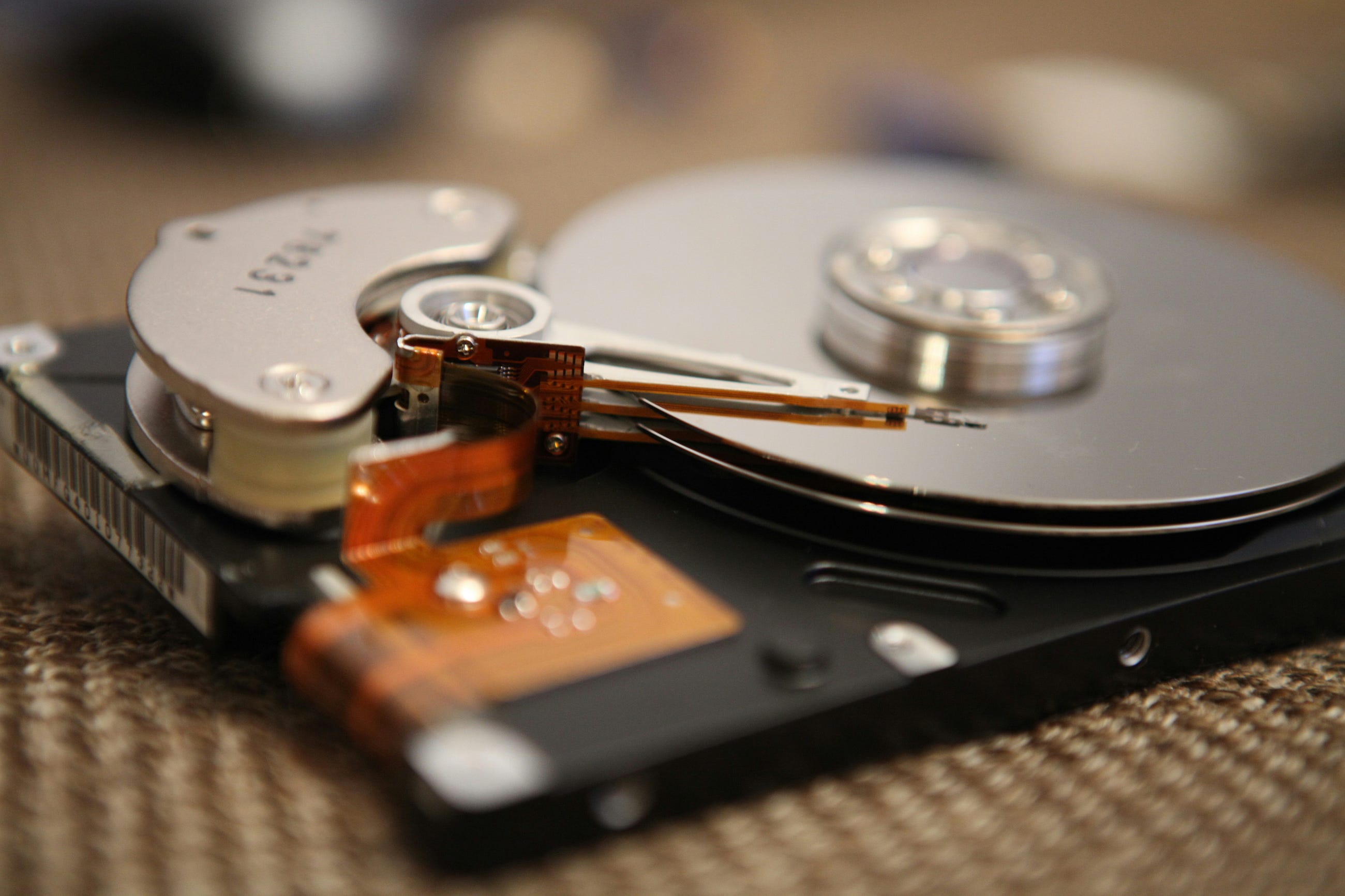 Açılmış hard disk'in içi, okuma-yazma kafası ve döner platterle bilgisayar depolama teknolojisini gösteriyor.